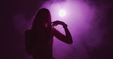 Şık genç kız, eflatun ışıkta serin dans, gece gizemli dans.