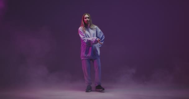 4k video di una ragazza elegante, fresco ballare in una felpa con cappuccio in luce al neon in studio. Moderna danza hip hop — Video Stock