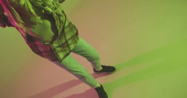 4k video di una giovane ragazza alla moda, danza fresca moderna danza funky in luce colorata al neon in studio — Video Stock