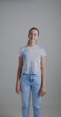 Moda blogcusu genç kız el çırpıyor. Genç kızların sosyal medya için telefonda dikey video blogları yazılıyor