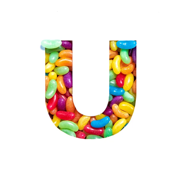 Lettera U dell'alfabeto inglese fatta di caramelle di gelatina di fagioli arcobaleno e taglio di carta isolato su bianco. Caratteri festivi — Foto Stock