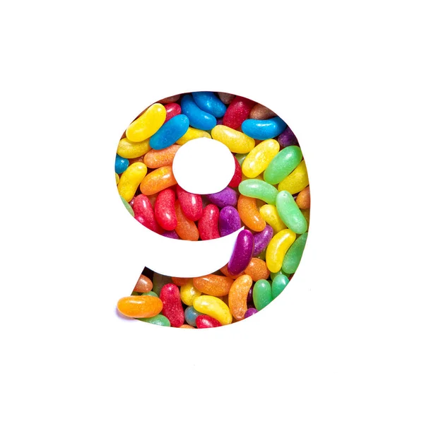 Номер дев'ять барвистих цукерок желе і папір вирізані у формі дев'ятої цифри ізольовані на білому. Веселка шрифт — стокове фото