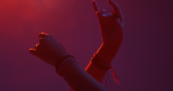 Sluiten van handen met armbanden. Meisje dansend hete dans in nachtclub met rook. Kleurrijk licht — Stockvideo