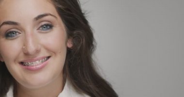 Diş tellerine göre diziliş. Genç bayan güler yüzlü. Diş bakımı, ortodontik tedavi. Reklamcılık için eşdeğer alan