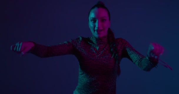 Stijlvolle jonge gemengde ras meisje dansen hip-hop in neon studio licht. Professionele vrouwelijke performer, expressie en ritme — Stockvideo