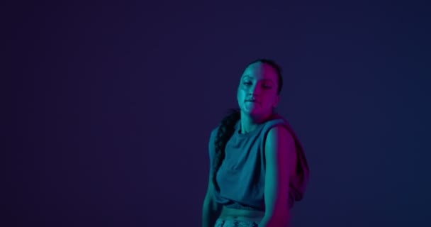 Ung blandras flicka dansar afrikansk eldig dans i neonljus. Professionell kvinnlig artist, uttryck och rytm — Stockvideo