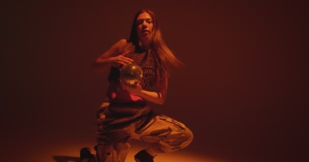 Stylowa młoda dziewczyna z disco ball taniec namiętny gorący taniec na podłodze w centrum uwagi w studio. Ogniste działanie — Wideo stockowe