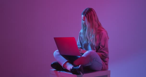 4k vídeo de la muchacha moderna con el ordenador portátil, tablet. Libre creatividad. Joven blogger escribiendo luz de neón de colores — Vídeo de stock