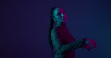 Neon Stüdyo ışıkları altında ateşli dans eden genç ırk kızı. Profesyonel kadın sanatçı, ifade ve ritim