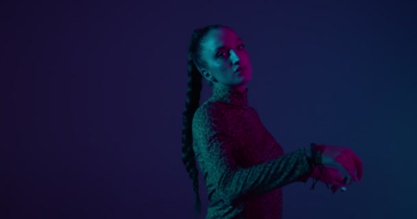 Ung blandras flicka dansar eldig dans i neon studio ljus. Professionell kvinnlig artist, uttryck och rytm — Stockvideo