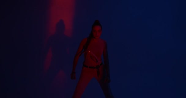 Jong meisje dansen gepassioneerde dans of hip-hop in kleurrijk licht. Professionele vrouwelijke performer, expressie en ritme — Stockvideo