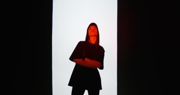 Elegante bailarina joven de 20 años en traje negro fresco moviéndose en luz roja en el estudio. Danza contemporánea, rap y hip hop — Vídeos de Stock