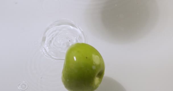 Manzanas verdes rebotan en el agua con salpicaduras, frutas naturales, vista superior. Vitaminas, concepto de alimentación saludable — Vídeo de stock