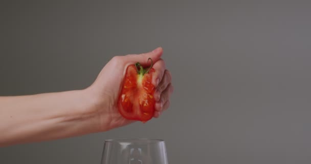 Main féminine presser le jus naturel frais hors des tomates, gouttes tombant dans le verre. Vitamines et saine alimentation — Video