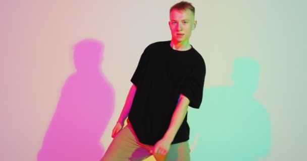 Dancing young guy cool moving in colourful studio light. Contemporary dance, hip hop freestyle. Advertising video — Stock Video