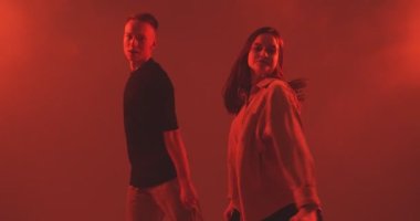 Dans eden genç çift, stüdyoda dumanla tutkuyla hareket ediyor. Çağdaş dans, hip hop dansçılarının gösterisi