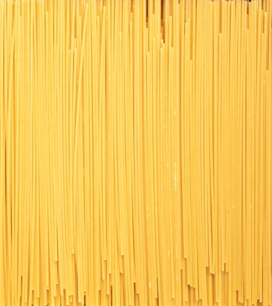 Italian food, pasta wallpaper for grocery products packaging design. Yellow background made of bio organic spaghetti — Stock Photo, Image