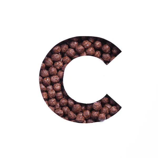 Buchstabe C des Alphabets aus Bio-Schokolade-Müslibällchen und Papier isoliert auf weiß geschnitten. Schrift für einen gesunden Lebensmittelladen — Stockfoto