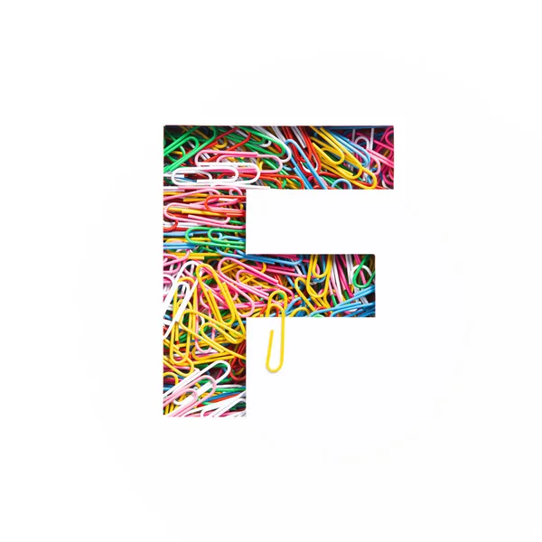 Lettera F dell'alfabeto inglese di colorate graffette arcobaleno, foglio di carta bianco tagliato. Tipo di materiale per ufficio — Foto Stock