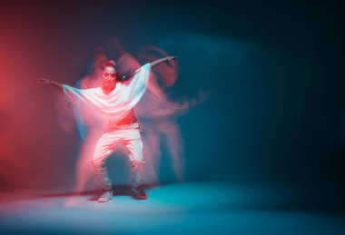 Çağdaş hip hop dansı. Renkli neon renkli stüdyo ışığında dans eden modern kız. Uzun pozlama. Boşluğu kopyala.