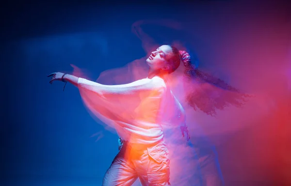 Taniec młoda mieszana dziewczyna wyścig ciesząc się w kolorowe neonowe światło studio. Długa ekspozycja. Etniczny taniec ognisty — Zdjęcie stockowe