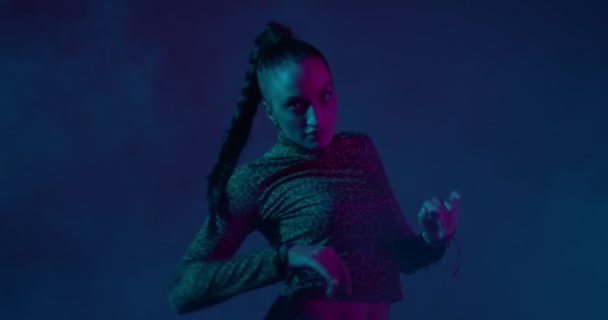 Gemengde race meisje dansen etnische vurige dans of hip-hop in neon studio licht. Uitdrukking en ritme — Stockvideo