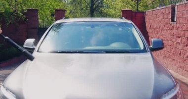 Araba yıkama ve temizlik. Profesyonel bir işçi araba kaputunu çamaşır makinesiyle yıkıyor. Otomobillere dikkat et