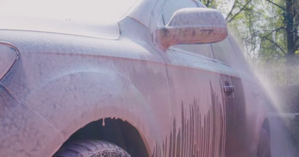 Close-up of covering car by soap foam on car exterior in car wash, auto service. Carwash, car detailing concept — Wideo stockowe