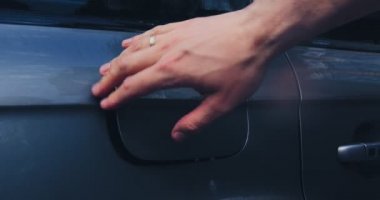 Dış araba temizliği. Oto yıkamacıda çalışan biri, basınçlı yıkama makinesi kullanıyor, arabaya su püskürtüyor, parlatıcı için benzin deposu yıkıyor.