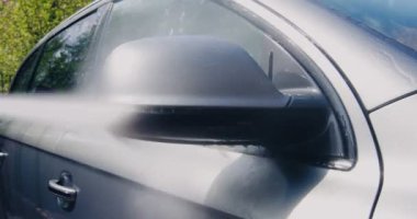 Oto yıkamadaki servis, oto yıkamacıda araba aynasını yıkayan profesyonel bir işçi.