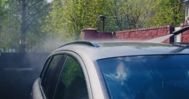 Araba yıkama ve temizlik. Araba servisinde araba yıkama makinesiyle araba yıkayan profesyonel bir işçi.