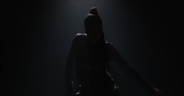 Menina legal dançando dança étnica apaixonada ou hip-hop em destaque no estúdio escuro. Dançarina mostra movimentos rítmicos — Vídeo de Stock