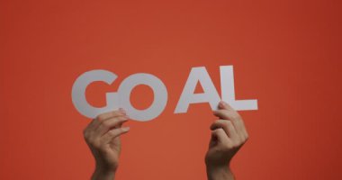 Eller İngilizce 'nin amacını gösteriyor. Adam blog için oyulmuş kağıttan yapılmış motive edici spor sözcüklerini gösteriyor