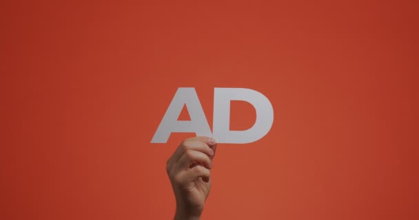 Hand opvoeden met woord reclame. Man toont reclame teken gemaakt van gesneden papier voor blog screensaver — Stockvideo