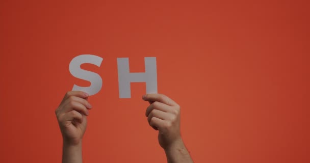 Händerna visar ordet sh. Man visar utrop tystnad tecken av snidat papper för blogg skärmsläckare, serier — Stockvideo
