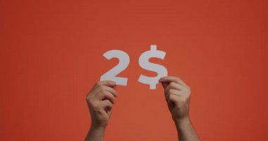 Elleri iki dolar gösteriyor, satın alma maliyeti. Adam oyulmuş kağıttan yapılmış fiyat gösteriyor. İndirim, bağış, açık artırma konsepti