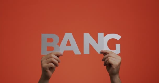 Tangan menunjukkan kata Bang bahasa Inggris yang terbuat dari kertas berukir untuk screen saver blog, komik — Stok Video