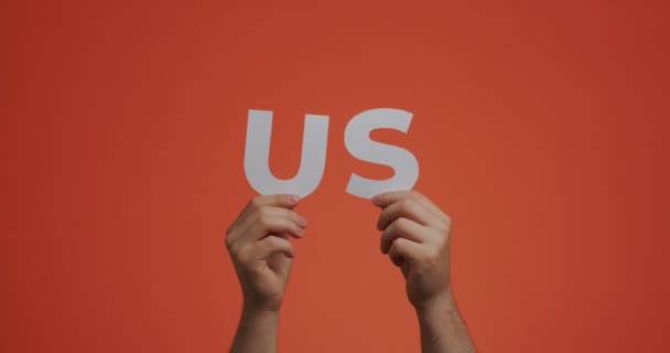 Руки вгору, показуючи слова США. Чоловік показує США знак різьбленого паперу для блогу — стокове відео