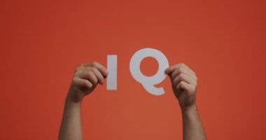 Eller yukarı, IQ işaretini gösteriyor. İnsan, blog ve ekran koruyucusu için oyulmuş kağıttan yapılmış zeka miktarını gösterir