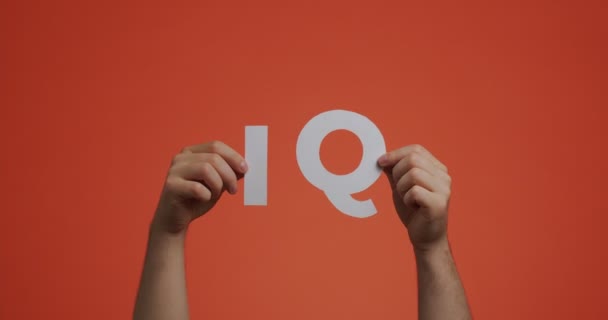 Руки вверх, показывая знак IQ. Человек показывает коэффициент интеллекта, сделанный из резной бумаги для блога, заставки — стоковое видео