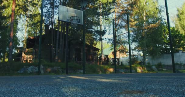 Bola de basquete rolando na superfície do campo ao ar livre. Publicidade para loja de equipamentos esportivos, estilo de vida desportivo saudável — Vídeo de Stock