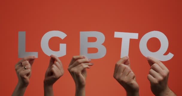 Cultura Lgbt, concepto de derechos de género. Levantando las manos mostrando el letrero lgbtq hecho de papel tallado para bloguear — Vídeos de Stock