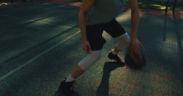 Профессиональный американский баскетболист крутой парень в действии с мячом капает на корте на открытом воздухе, закрыть — стоковое видео
