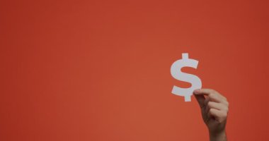 Dolar işaretini gösteren el kaldırma. Adam oyulmuş kağıttan yapılmış para sembolü gösteriyor. Bankacılık, değişim konsepti