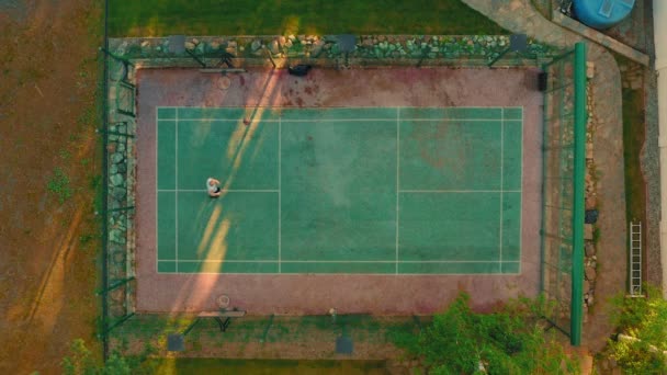 Tiro aéreo do campo de basquetebol. Vista aérea do treinamento de jogador de basquete, marcando um aro ao ar livre no verão — Vídeo de Stock