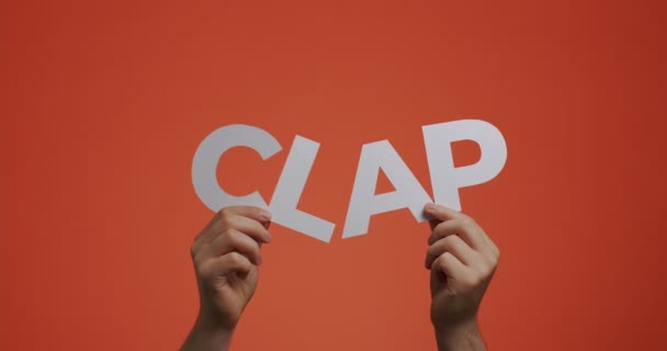 Manos mostrando el aplauso de la palabra del idioma inglés. Hombre aplaudiendo espectáculo palabra hecha de papel tallado para el salvapantallas blog, cómics. — Vídeos de Stock