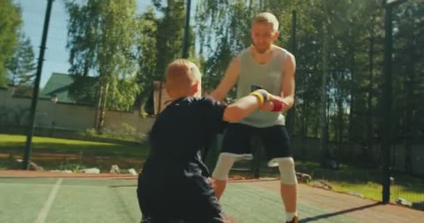 프로 농구 선수 강사는 휴대 전화를 들고 사회 연결망을 위한 비디오를 찍는 어린 소년을 훈련 시킨다 — 비디오