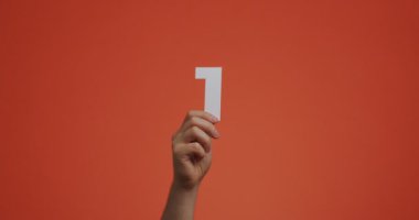 Bir numarayı gösteriyor. Rakamlı kol, blog, oy verme, mağaza satışı veya eğitim için oyulmuş kağıttan yapılmış ilk numara