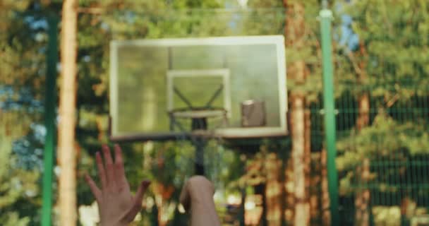 Close-up professionele basketbalspeler gooien bal mikken in hoepel buiten in de zomer op basketbalveld — Stockvideo