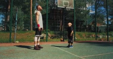 Basketbolcular antrenmandan önce ısınma egzersizi yapıyorlar. Basketbol sahasında spor eğitmeni. 